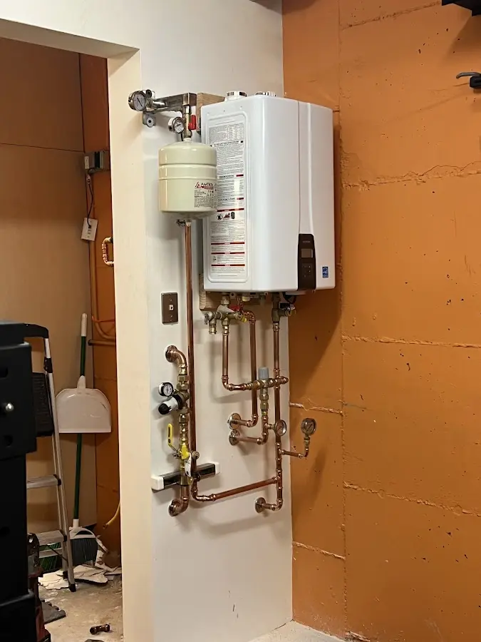 Plumbing technician inspecting water heater connections in Friona